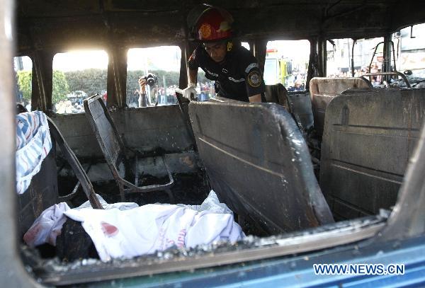 A firefighter works inside the remains of a charred bus in Guatemala City, capital of Guatemala, on Jan. 3, 2011. Authorities informed that at least 5 people traveling on the bus were burned to death, and 16 others suffered severe burns after a bomb thrown by an unidentified person hit the vehicle.[Xinhua] 