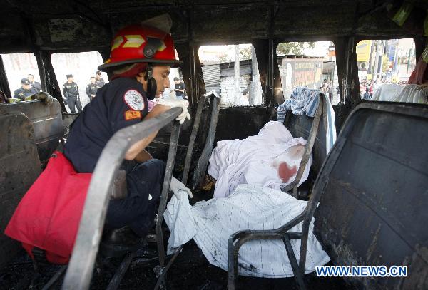 A firefighter inspects the inside of a charred bus in Guatemala City, Guatemala&apos;s capital, on Jan. 3, 2011. Authorities informed that at least 5 people traveling on the bus were burned to death, and 16 others suffered severe burns after a bomb thrown by an unidentified person hit the vehicle.[Xinhua]