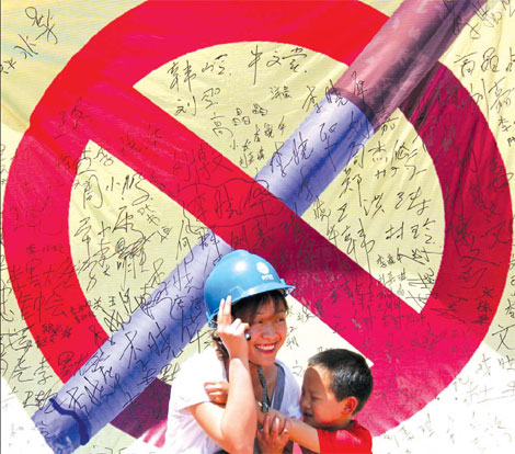  A power plant worker smiles at Tangyin, Henan province, after signing her name on a campaign board to promote tobacco control. Volunteers who signed the names on the board vowed to stay away from cigarettes. [File photo/China Daily]