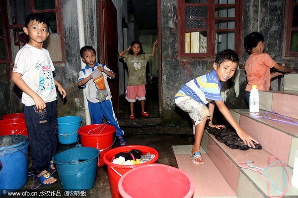 Children play at the packed 'home for left-behind students,' where beds are placed in the corridor and shoes are kept on the stairs, in Shitai township of Yingde city, South China's Guangdong province. Photo taken on Sept 19, 2010. 