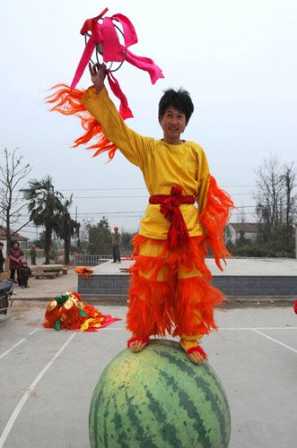 A lion dancer poses for photos as villagers dance to celebrate the Chinese Lunar New Year, or Spring Festival, which falls on Feb 3 this year, in Hongxingqiao township, East China&apos;s Zhejiang province, Jan 5, 2011. [Xinhua] 
