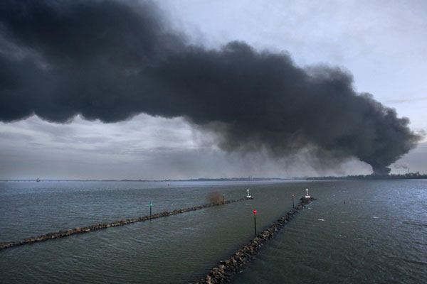 Smoke billows above an industrial zone after a fire broke out at a chemicals plant at the Dutch industrial zone of Moerdijk Jan 5, 2011. [China Daily/Agencies]