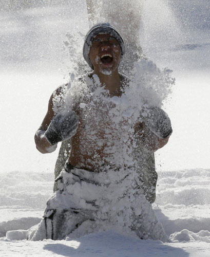 A member of the Republic of Korea Special Warfare Force hurls snow on his body during a winter exercise in Pyeongchang, the Republic of Korea, Jan 4, 2011. [China Daily/Agencies]