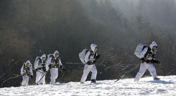 Members of the Republic of Korea Special Warfare Forces hurl snow on their bodies during a winter exercise in Pyeongchang, the Republic of Korea, Jan 4, 2011. [China Daily/Agencies]