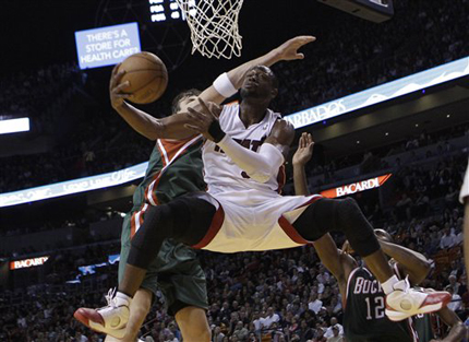 Miami Heat guard Dwyane Wade shoots as Milwaukee Bucks center Andrew Bogut, left, defends in the fourth quarter of an NBA basketball game in Miami, yesterday. The Heat defeated the Bucks 101-89.