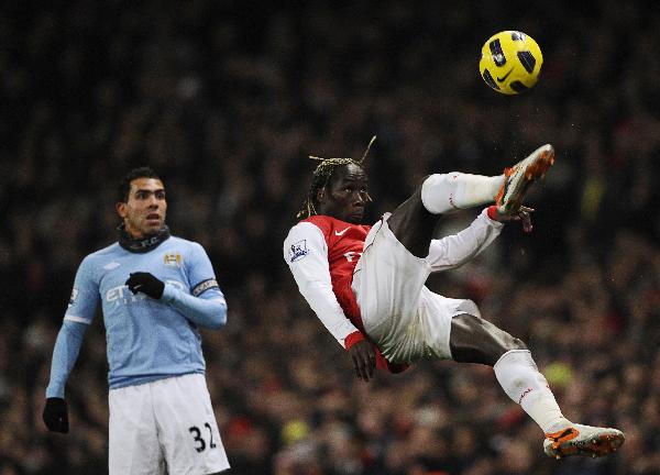Arsenal's Bacary Sagna (R) volleys the ball as Manchester City's Carlos Tevez reacts during their English Premier League soccer match at the Emirates Stadium in London January 5, 2011. (Xinhua/Reuters Photo)