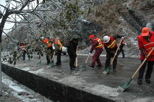 Staffers with the road management bureau shovel ice on the road in Ziyuan county, Southwest China&apos;s Guangxi Zhuang autonomous region, Jan 5, 2011.