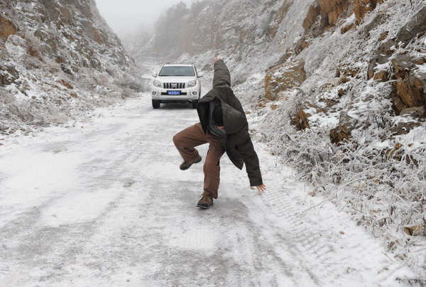 A driver slips on a road in Wulong county, Southwest China&apos;s Chongqing municipality, Jan 4, 2011.