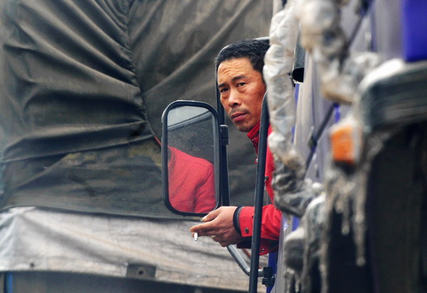 A driver looks out of his car stranded on the Huaihua section of NO 319 national highway in Central China&apos;s Hunan province on Jan 4, 2011. 20 sections of four national highways and 10 provincial highways in the province are closed due to thick ice on the road, according to the provincial highway management administration. 