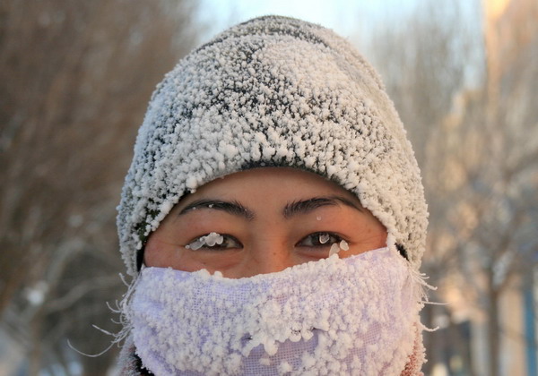 A sanitation worker smiles through a mask of ice on Wednesday in Karamay, a city in the Xinjiang Uygur autonomous region. Temperatures in the city dropped to below -30 C in recent days. [Photo/China News Service]