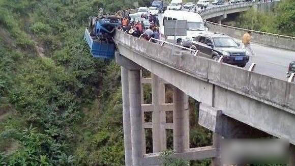 A truck driver lost control on a bridge in Northwest China&apos;s Qinghai province and managed to avoid plunging to the bottom of the 200-foot deep gorge, UK&apos;s Telegraph reported. Thanks to a single punctured tyre and some torn sheet metal near the diesel tank, the truck somehow managed to cling on to the concrete barrier, albeit upside down. The driver was plucked to safety by rescuers. [Undated photos posted online at Yahoo Autos]