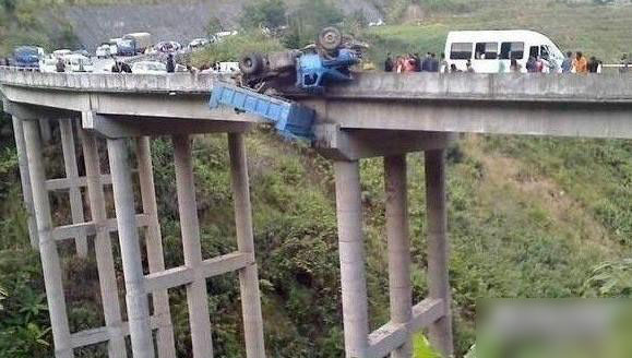 A Chinese truck driver cheated certain death after his vehicle somehow span out of control on a major road, clipped the concrete wall, and turned over the edge. The driver was plucked to safety by rescuers. [Undated photos posted online at Yahoo Autos] 