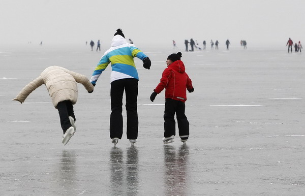 An ice skater falls while skating with two other ice skaters on the frozen Lake Neusiedl (Neusiedlersee) in Austria&apos;s eastern province of Burgenland, some 60 km (37 miles) east of Vienna January 6, 2011. Lake Neusiedl is a steppe lake in Europe and was appointed on the basis of the unique flora and fauna to a UNESCO World Heritage Site.[China Daily/Agencies] 