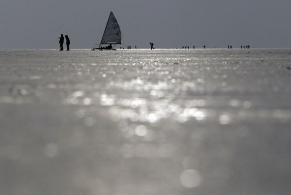 An ice sailing boat is seen between ice-skaters on the frozen Lake Neusiedl (Neusiedlersee) in Austria&apos;s eastern province of Burgenland, some 60 km (37 miles) east of Vienna January 6, 2011. Lake Neusiedl is a steppe lake in Europe and was appointed on the basis of the unique flora and fauna to a UNESCO World Heritage Site.[China Daily/Agencies]