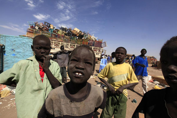 Southern Sudanese boys in the north watch a truck being loaded with belongings as it prepares to leave for the south before the secession referendum, in an area called Mandela in Khartoum, Jan 5, 2011. 