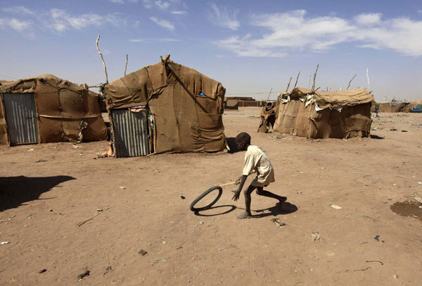 A Southern Sudanese boy in the north plays beside shelters in an area called Mandela in Khartoum Jan 5, 2011. [China Daily/Agencies]