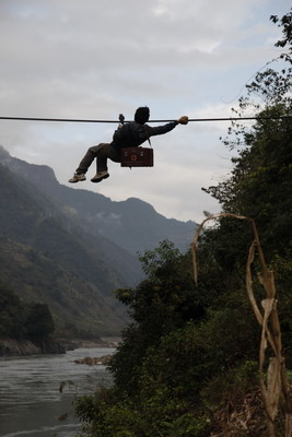 Li Jiasheng crosses the Nujiang River by sliding on a 400-meter-long zip line. 