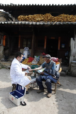 Rural doctor Yang Changlin checks the blood pressure of a farmer in Sanying village, Eyuan county, Dali Bai autonomous prefecture in Yunnan province.