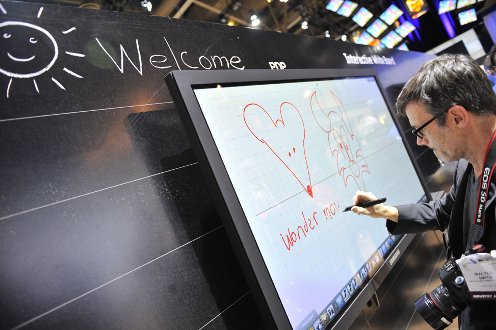 A customer try out the interactive white board during the 2011 International Consumer Electronics Show in Las Vegas, the United States, Jan 7, 2011. [Xinhua]