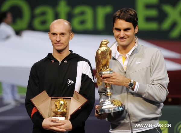 Roger Federer (R) of Switzerland poses with the golden eagle trophy next to Nikolay Davydenko of Russia during the awarding ceremony for the Qatar Open tennis tournament in Doha, capital of Qatar, Jan. 8, 2011. Federer won the final by 2-0. [Xinhua]