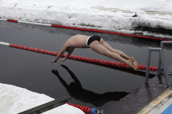 A man dives into the water at a winter swimming festival in Tallinn Jan 8, 2011. [China Daily/Agencies]