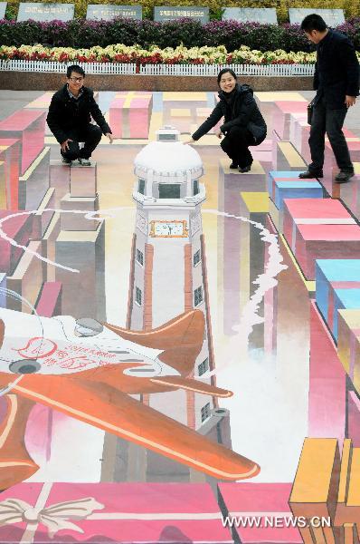 Citizens stand on a 3D painting for photo on a street in southwest China&apos;s Chongqing Municipality, Jan. 8, 2011. According to the designer, it took 26 days to finish the 3D painting which covers an area of nearly 90 square meters. [Xinhua]