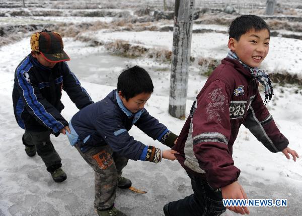Children play at a road covered with snow and ice in a village in Quanzhou County of south China&apos;s Guangxi Zhuang Autonomous Region, Jan. 8, 2010. Despite the difficulty that cold weather brought to local people&apos;s life, children enjoy the fun with the snow-covered world. [Xinhua]