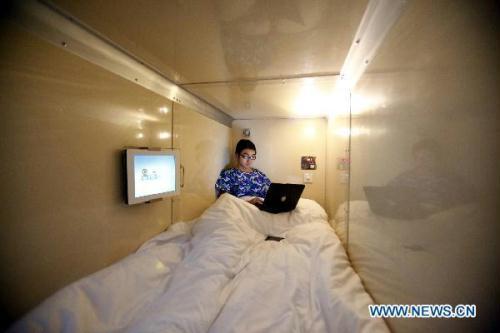 A staff member tries the bed at a &apos;capsule inn&apos; in Shanghai, east China, Jan. 6, 2010. A &apos;capsule inn&apos; covering an area of more than 300 square meters with 68 cuboids where guests could rest will open near Shanghai Railway Station soon. There are independent power sockets, clocks, lights and flat screen televisions inside the cuboids. Guests could also enjoy wireless internet service at the &apos;capsule inn&apos;. [Fan Xiaoming/Xinhua]