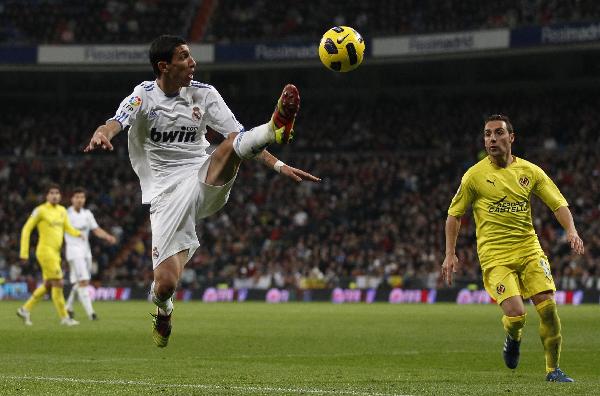 Real Madrid's Angel Di Maria (L) controls the ball next Villarreal's Angel Lopez during their Spanish first division soccer league match against Villareal at the Santiago Bernabeu stadium in Madrid January 9, 2011. (Xinhua/Reuters Photo)