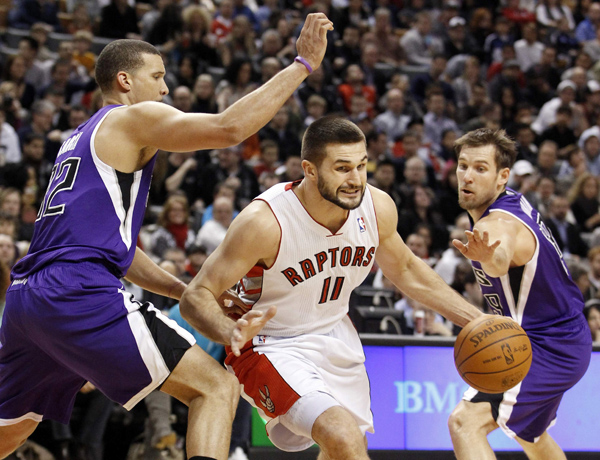 Toronto Raptors forward Linas Kleiza (C) drives to the basket between Sacramento Kings defenders Francisco Garcia and Beno Udrih (R)during the first half of their NBA basketball game in Toronto January 9, 2011. Toronto Raptors beat Sacramento Kings118-112.(Xinhua/Reuters Photo)