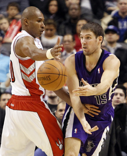 Sacramento Kings guard Beno Udrih passes the ball past Toronto Raptors defender Leandro Barbosa (L) during the first half of their NBA basketball game in Toronto January 9, 2011. (Xinhua/Reuters Photo)