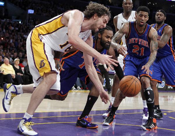 Los Angeles Lakers Pau Gasol of Spain (L) chases down the ball after being fouled by New York Knicks Ronny Turiaf of France (2nd L) during their NBA basketball game in Los Angeles, California, January 9, 2011. (Xinhua/Reuters Photo)