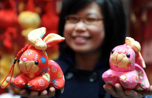 A citizen shows two rabbit toys at a store in Nanchang, capital of central China's Jiangxi Province, Jan. 9, 2011. The year 2011 is the 'Year of the Rabbit' under the 12-year Chinese lunar calendar in which each year is named after one of the twelve Chinese zodiac animals in turn. Therefore, besides traditional decorations for the Spring Festival, products related to rabbit won popularity among buyers this year. 