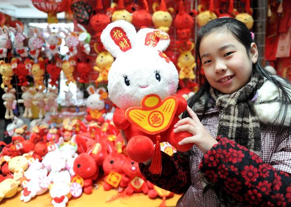 Ding Wenjie shows her toy at a store in Nanchang, capital of central China's Jiangxi Province, Jan. 9, 2011. The year 2011 is the 'Year of the Rabbit' under the 12-year Chinese lunar calendar in which each year is named after one of the twelve Chinese zodiac animals in turn. Therefore, besides traditional decorations for the Spring Festival, products related to rabbit won popularity among buyers this year. 