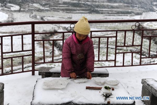 A child plays with snow and ice in a village in Quanzhou County of south China&apos;s Guangxi Zhuang Autonomous Region, Jan. 8, 2010. Despite the difficulty that cold weather brought to local people&apos;s life, children enjoy the fun with the snow-covered world. 