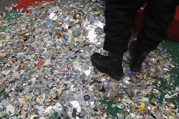 Fragments of destroyed pirated DVDs are seen on the floor during a campaign against the production and distribution of porn and pirated publications, at a photo opportunity inside a gymnasium in Beijing Jan 10, 2011. [Photo/Agencies]