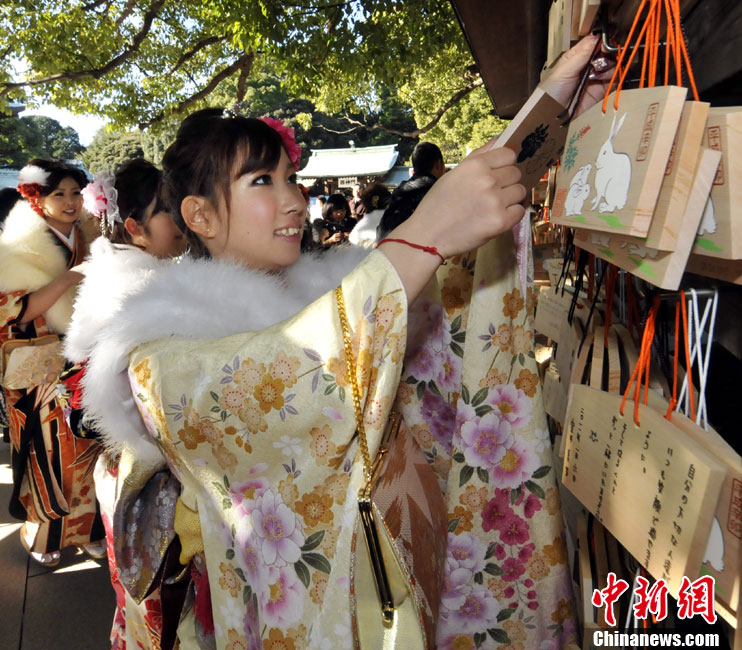 Japanese women in kimonos watch the wishes written on the small planks in Meiji Shrine during their Coming of Age Day event in Tokyo Jan 10, 2011.[Chinanews.com]