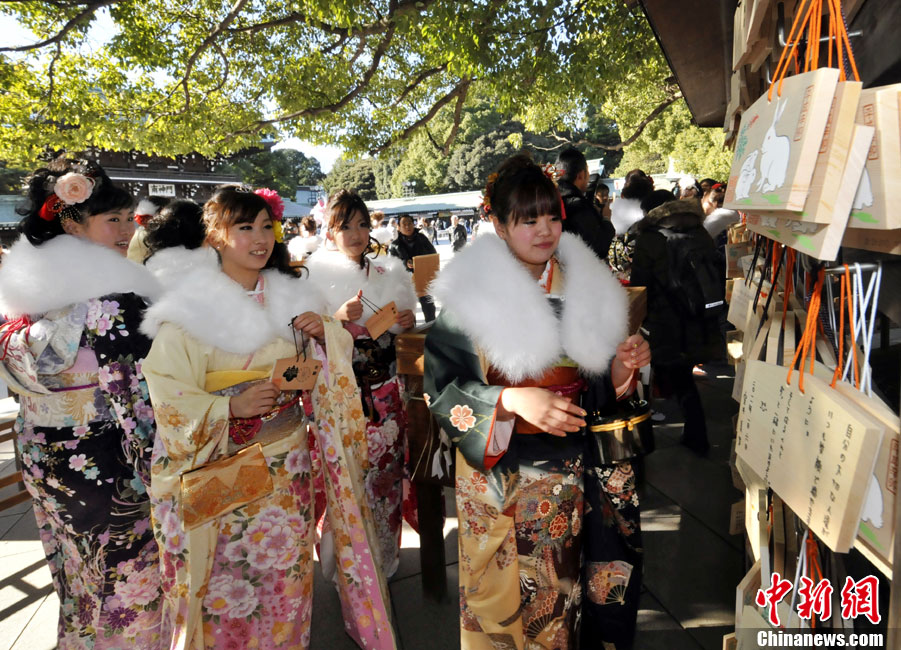 Japanese women in kimonos watch the wishes written on the small planks in Meiji Shrine during their Coming of Age Day event in Tokyo Jan 10, 2011.[Chinanews.com]