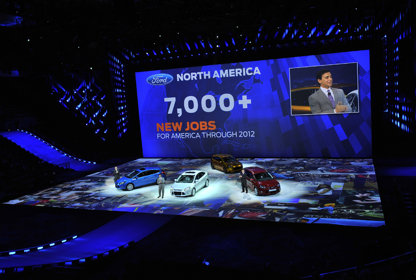 Bill Ford Jr., executive chairman of Ford Motor Company stands beside a Ford Focus electric car during the press day for the North American International Auto show in Detroit, Michigan Jan 10, 2011. [Photo/Xinhua]