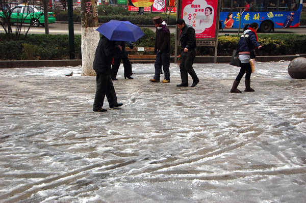 Local residents walk carefully on an icy road in Kaili city, South China&apos;s Guizhou province, Jan 10, 2011. The city was hit by another round of inclement weather Monday. Freezing weather in South China has forced the evacuation of at least 58,000 people from their homes over the past week, according to the Ministry of Civil Affairs. [Photo/Xinhua]