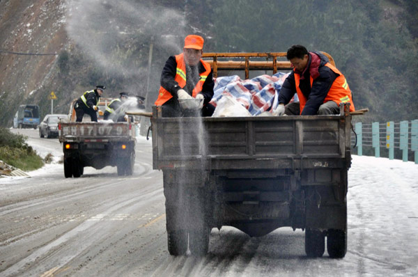 Road management workers sprinkle salt on an icy road to help the ice melt in Kaili city, South China&apos;s Guizhou province, Jan 10, 2011. [Photo/Xinhua]