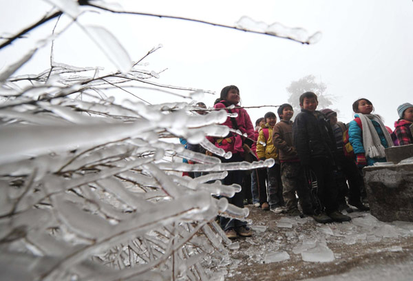 Children gather in an icy playground to wait for their parents and teacher to take them home after school in Dayuan village, Quanzhou county, South China&apos;s Guangxi Zhuang autonomous region, Jan 10, 2011. [Photo/Xinhua]