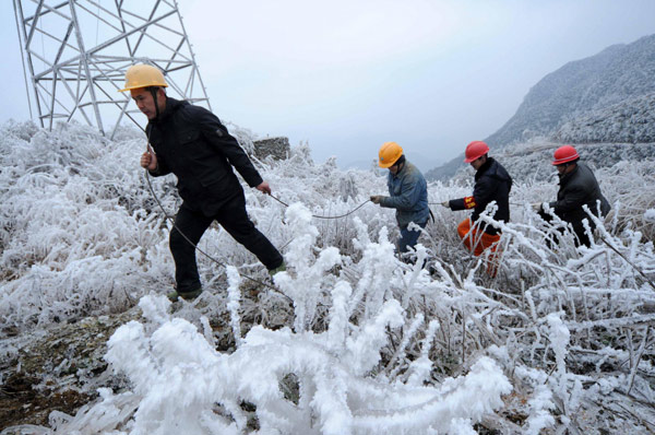 Workers fix ice-covered electric wires in Leishan county, Southwest China&apos;s Guizhou province, Jan 9, 2011. [Photo/Xinhua] 