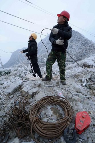 Workers fix ice-covered electric wires in Leishan county, Southwest China&apos;s Guizhou province, Jan 9, 2011. [Photo/Xinhua]