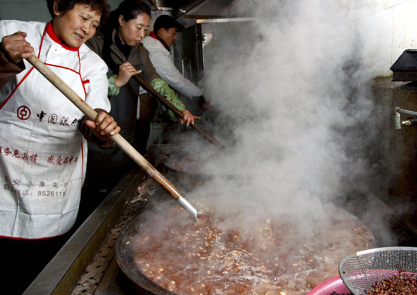 Staffers at a temple in Xi&apos;an of Northwest China&apos;s Shaanxi province cook Laba rice porridge ahead of Laba Festival, which falls on Jan 11 this year. The Laba Festival, which falls on the eighth day of the twelfth month on the lunar calendar, commemorates Sakyamuni Buddha&apos;s enlightenment. Chinese celebrate the day by eating Laba porridge, which is made with rice, nuts, cereal and dried fruit. [Photo/Xinhua]