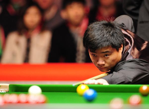 Ding Junhui of China plays a shot during his first-round match against Mark Williams of Wales in 2011's Snooker Masters held at the Wembley Arena in London, Britain, Jan. 10, 2011. Ding won by 6:4 to enter the quarter-finals. (Xinhua/Zeng Yi) 