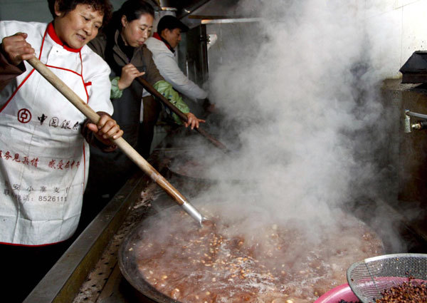 Staffers at a temple in Xi'an of northwest China's Shaanxi Province cook Laba rice porridge ahead of Laba Festival, which falls on Jan. 11 this year. The Laba Festival, which falls on the eighth day of the twelfth month on the lunar calendar, commemorates Sakyamuni Buddha's enlightenment. Chinese celebrate the day by eating Laba porridge, which is made with rice, nuts, cereal and dried fruit. [Photo/Xinhua]
