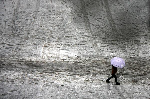 A man walks on a road coated by ice and snow in Guiyang City, capital of southwest China&apos;s Guizhou Province on Jan. 10, 2011. Another wave of freezing rain and sleet and low temperature hit Guizhou Province Monday. Most segments of the inner-provincial highways were affected. At 08:00 of Monday, Jinyang Coach Station, the largest one in the province, suspended the passenger transport services it provided. [Xinhua] 