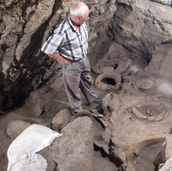 Archaeologist Levon Petrosyan looks at a 6,100-year-old wine-making equipment discovered by an international project at the excavations of the Areni-1 cave complex in Armenia, in this undated photograph released to Reuters on Jan 10, 2011. [China Daily/Agencies]