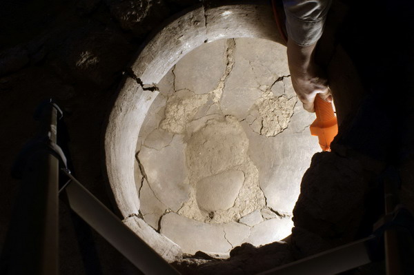 A flashlight illuminates the inside of the vat into which the wine press drained in this undated photograph released to Reuters on Jan 10, 2011. [China Daily/Agencies]